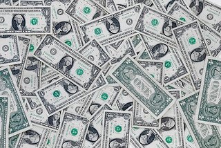 A scattered pile of US one-dollar bills.