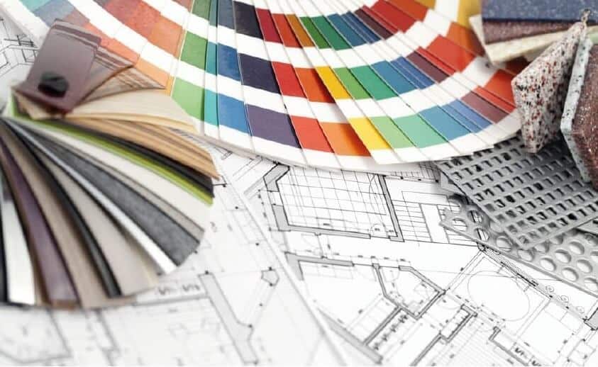 Color swatches, architectural plans, and material samples arranged on a table.