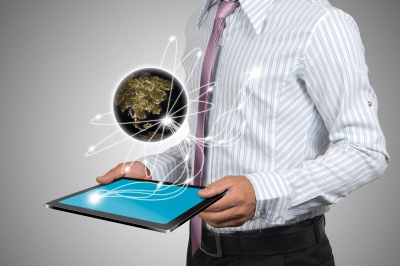 Man holding tablet with holographic globe and data lines above it.